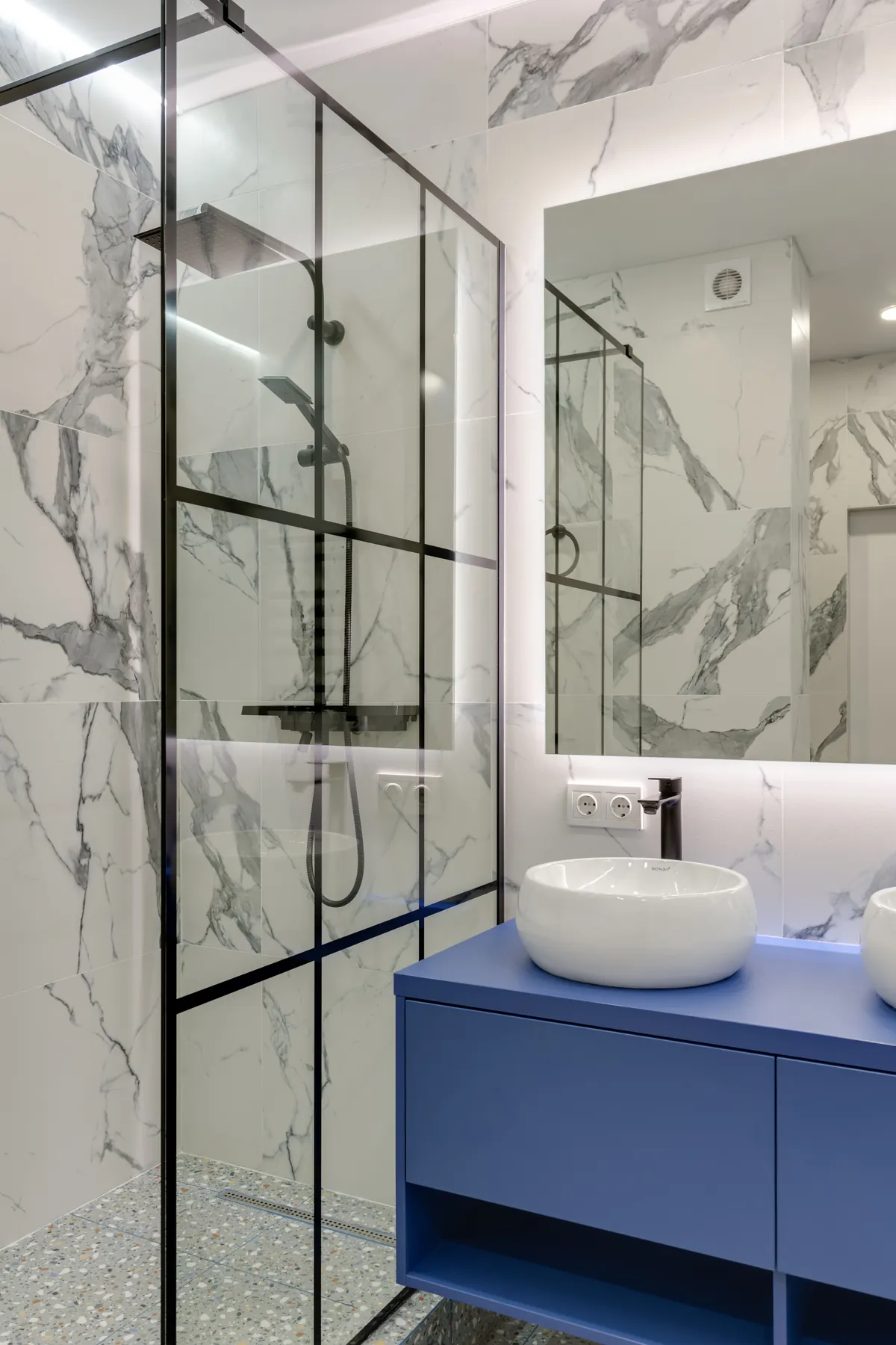 Shower, basin, and chrome fixtures in a modern bathroom