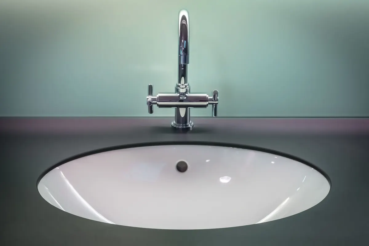 Chrome basin faucet installed in a tiled bathroom