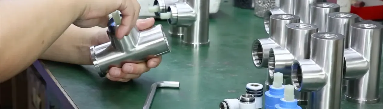 Batch of stainless steel tee bodies on an assembly bench